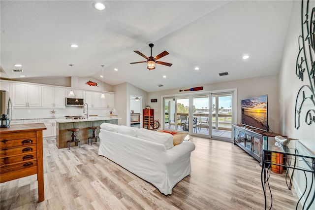 4469 Bahama Dr, Hernando Beach, FL 34607 - living room featuring vaulted ceiling, light wood finished floors, a ceiling fan, and recessed lighting