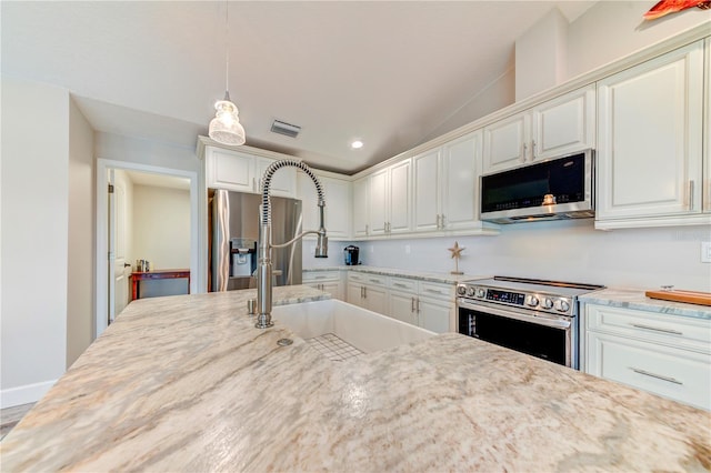 4469 Bahama Dr, Hernando Beach, FL 34607 - kitchen featuring appliances with stainless steel finishes, a sink, white cabinetry, light stone countertops, and recessed lighting