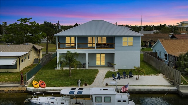 4469 Bahama Dr, Hernando Beach, FL 34607 - back of house at dusk with a patio area, a water view, a balcony, metal roof, and central air condition unit