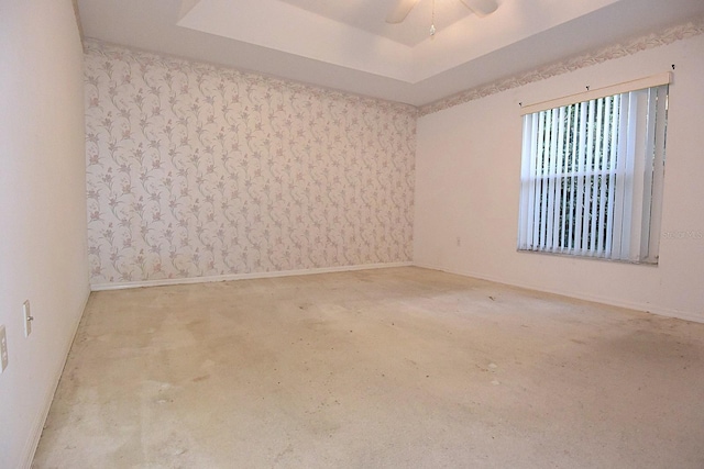 14112 Whitecap Ave, Hudson, FL 34667 - empty room featuring a raised ceiling, carpet, baseboards, and ceiling fan
