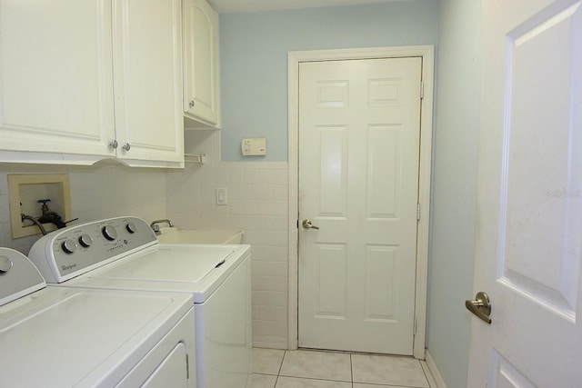 14112 Whitecap Ave, Hudson, FL 34667 - laundry area with cabinet space, light tile patterned floors, washing machine and clothes dryer, and tile walls