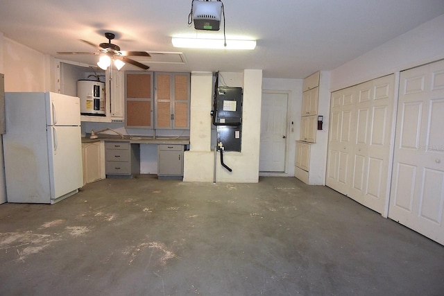 14112 Whitecap Ave, Hudson, FL 34667 - garage with freestanding refrigerator, a garage door opener, a ceiling fan, and electric water heater