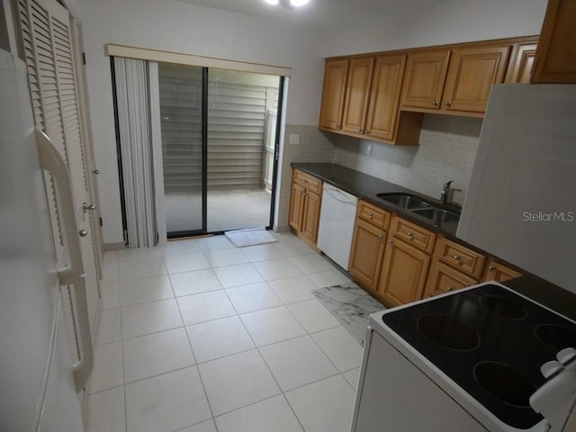 13010 Wedgewood Way Unit A, Hudson, FL 34667 - kitchen with white appliances, a sink, dark countertops, brown cabinets, and backsplash