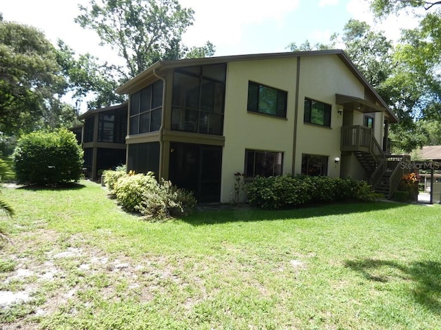 13010 Wedgewood Way Unit A, Hudson, FL 34667 - rear view of property with stairway, a lawn, a sunroom, and stucco siding