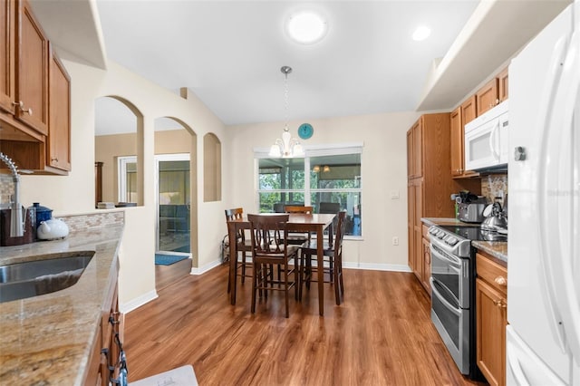 13444 English Parrot Rd, Brooksville, FL 34614 - kitchen featuring white appliances, a sink, a chandelier, and wood finished floors