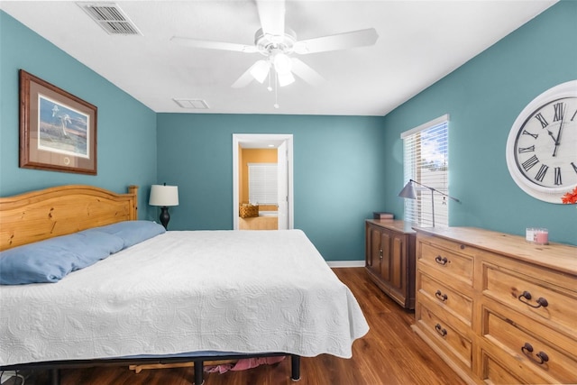 13444 English Parrot Rd, Brooksville, FL 34614 - bedroom with dark wood-type flooring, ceiling fan, baseboards, and ensuite bath