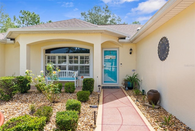 13444 English Parrot Rd, Brooksville, FL 34614 - view of exterior entry featuring stucco siding, roof with shingles, and a porch