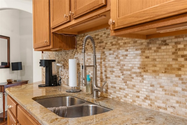 13444 English Parrot Rd, Brooksville, FL 34614 - kitchen with a sink, decorative backsplash, light stone countertops, and brown cabinets