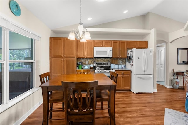 13444 English Parrot Rd, Brooksville, FL 34614 - kitchen featuring white appliances, lofted ceiling, a chandelier, decorative backsplash, and hanging light fixtures