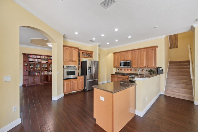 11726 Belle Haven Dr, New Port Richey, FL 34654 - kitchen featuring appliances with stainless steel finishes, arched walkways, dark countertops, recessed lighting, and dark wood-style floors