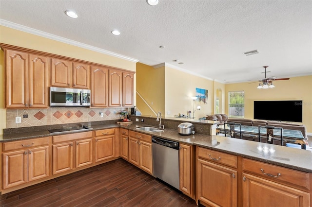 11726 Belle Haven Dr, New Port Richey, FL 34654 - kitchen with appliances with stainless steel finishes, a sink, a ceiling fan, decorative backsplash, and a textured ceiling