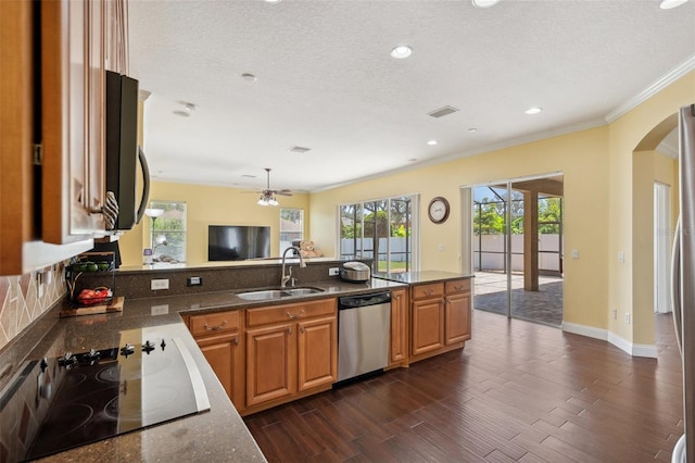 11726 Belle Haven Dr, New Port Richey, FL 34654 - kitchen with stainless steel appliances, a sink, arched walkways, ornamental molding, and a peninsula
