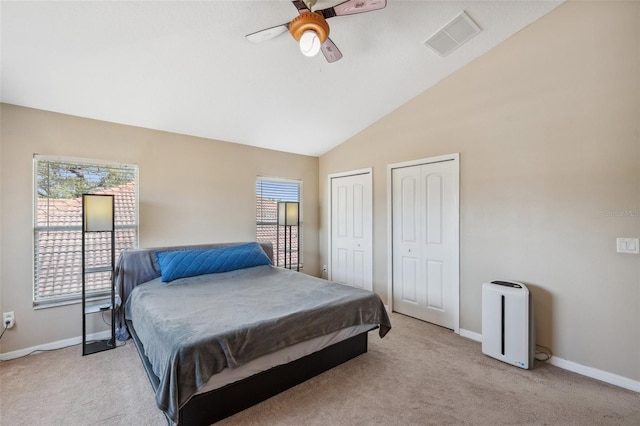 11726 Belle Haven Dr, New Port Richey, FL 34654 - bedroom featuring two closets, light colored carpet, baseboards, ceiling fan, and high vaulted ceiling