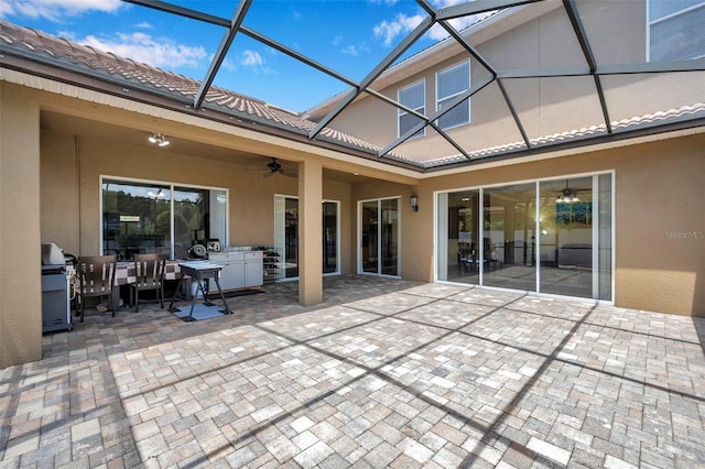 11726 Belle Haven Dr, New Port Richey, FL 34654 - rear view of house with a ceiling fan, stucco siding, a patio area, exterior kitchen, and a tiled roof