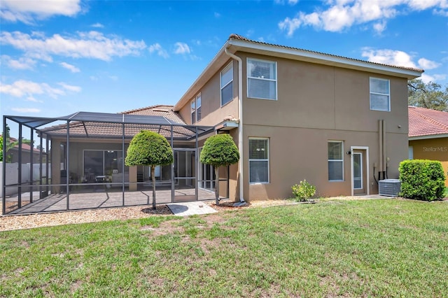 11726 Belle Haven Dr, New Port Richey, FL 34654 - rear view of house with stucco siding, a patio area, a lawn, a tiled roof, and glass enclosure