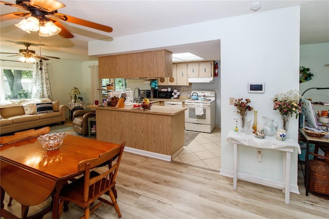 9630 Eldridge Rd, Spring Hill, FL 34608 - kitchen with white electric range oven, under cabinet range hood, a peninsula, ceiling fan, and a sink