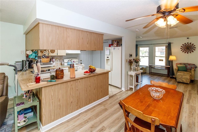 9630 Eldridge Rd, Spring Hill, FL 34608 - kitchen featuring white appliances, a peninsula, light wood-style flooring, ceiling fan, and light brown cabinetry