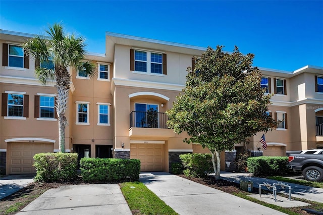 5032 Sand Castle Dr, New Port Richey, FL 34652 - view of property with stucco siding, an attached garage, driveway, and stone siding