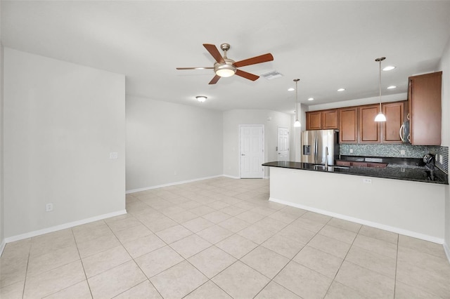 5032 Sand Castle Dr, New Port Richey, FL 34652 - kitchen featuring dark countertops, a ceiling fan, a peninsula, stainless steel appliances, and brown cabinetry