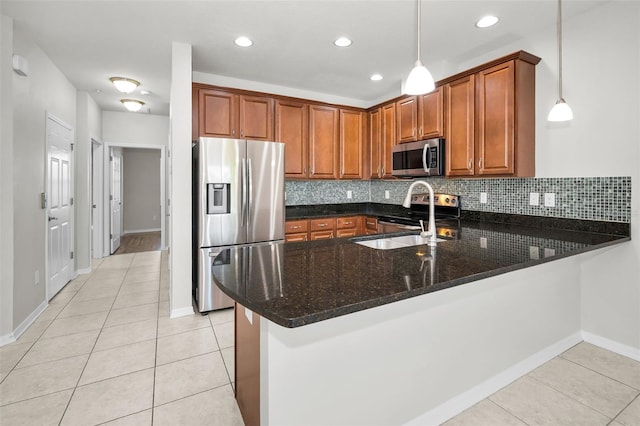 5032 Sand Castle Dr, New Port Richey, FL 34652 - kitchen featuring stainless steel appliances, a peninsula, light tile patterned flooring, dark stone counters, and decorative backsplash