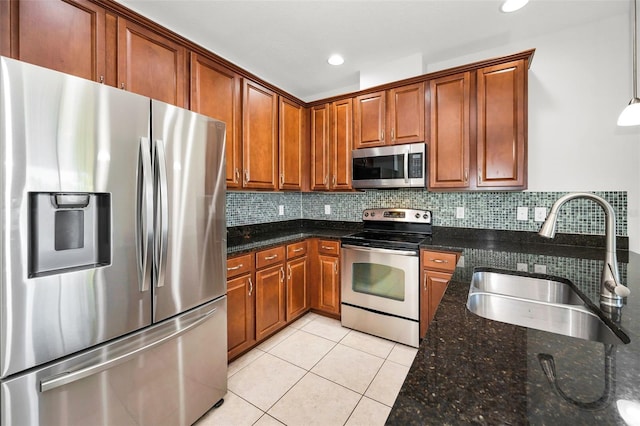 5032 Sand Castle Dr, New Port Richey, FL 34652 - kitchen with appliances with stainless steel finishes, light tile patterned floors, dark stone counters, tasteful backsplash, and brown cabinetry