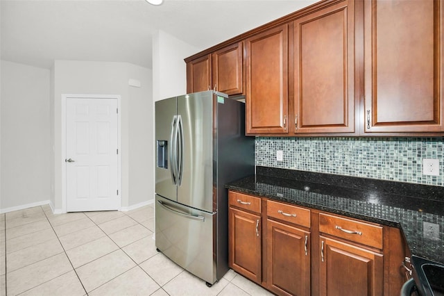 5032 Sand Castle Dr, New Port Richey, FL 34652 - kitchen with stainless steel fridge, light tile patterned flooring, backsplash, and dark stone counters