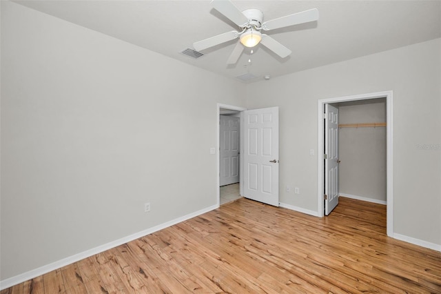 5032 Sand Castle Dr, New Port Richey, FL 34652 - unfurnished bedroom with light wood finished floors, a closet, a walk in closet, and a ceiling fan