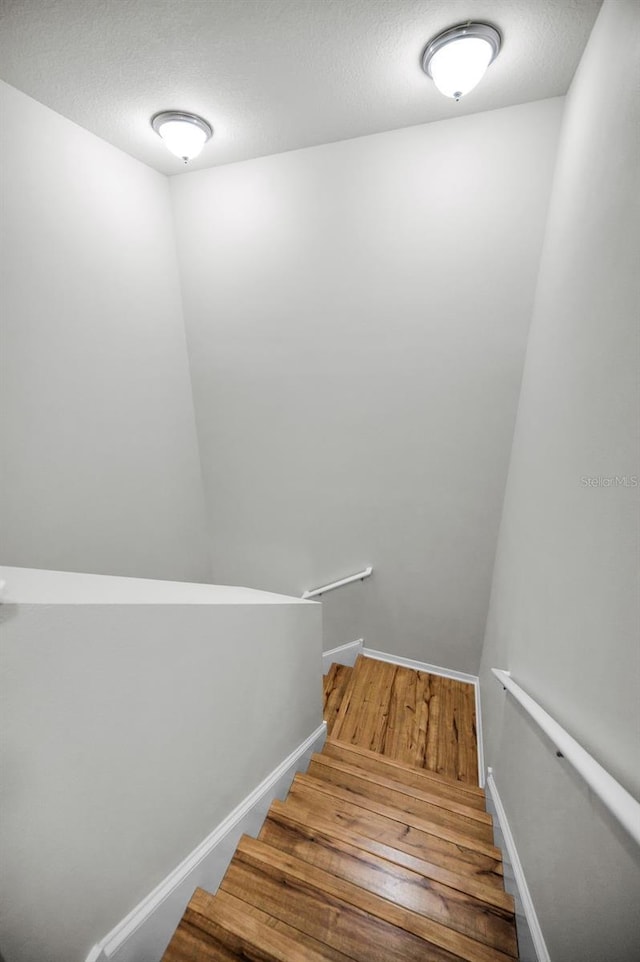 5032 Sand Castle Dr, New Port Richey, FL 34652 - staircase featuring wood finished floors and a textured ceiling