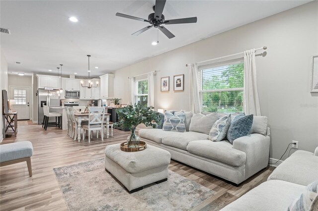 1601 E 98th Ave, Tampa, FL 33612 - living room with plenty of natural light, a ceiling fan, light wood finished floors, recessed lighting, and a chandelier