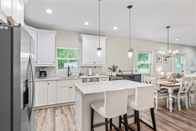1601 E 98th Ave, Tampa, FL 33612 - kitchen featuring stainless steel appliances, a sink, light wood-style floors, white cabinets, and light stone countertops