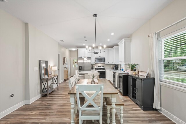 1601 E 98th Ave, Tampa, FL 33612 - dining area with light wood finished floors, baseboards, a chandelier, and recessed lighting