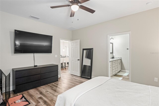 1601 E 98th Ave, Tampa, FL 33612 - bedroom with light wood finished floors, baseboards, ceiling fan, and ensuite bathroom