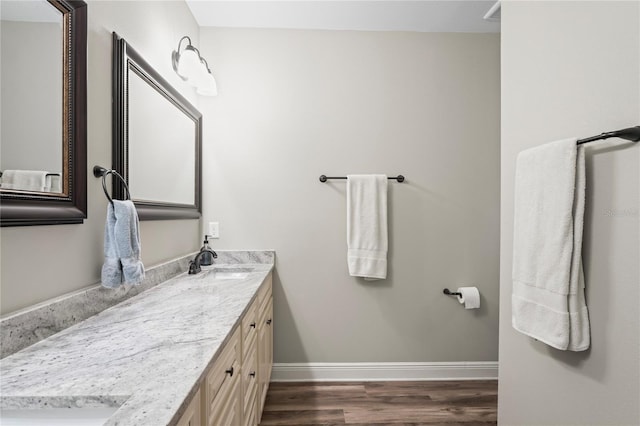 1601 E 98th Ave, Tampa, FL 33612 - bathroom featuring wood finished floors, double vanity, and baseboards