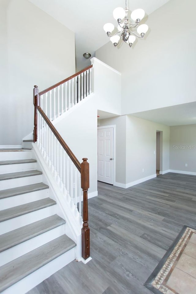 10386 Norvell Rd, Spring Hill, FL 34608 - staircase featuring a chandelier, wood finished floors, and a towering ceiling