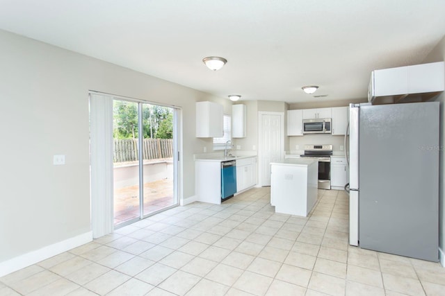 10386 Norvell Rd, Spring Hill, FL 34608 - kitchen featuring appliances with stainless steel finishes, light countertops, white cabinets, light tile patterned floors, and a center island