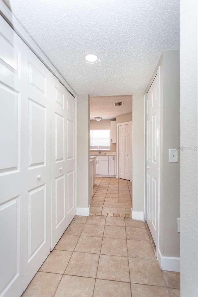 10386 Norvell Rd, Spring Hill, FL 34608 - hallway with a textured ceiling, light tile patterned floors, and recessed lighting