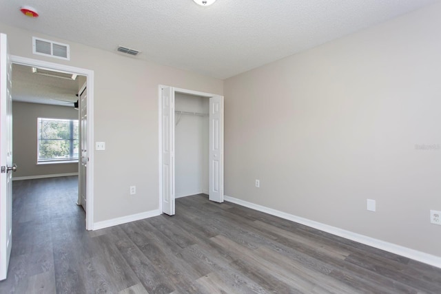10386 Norvell Rd, Spring Hill, FL 34608 - unfurnished bedroom featuring dark wood finished floors, a closet, and a textured ceiling