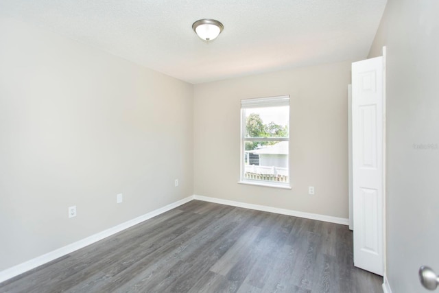 10386 Norvell Rd, Spring Hill, FL 34608 - unfurnished room with dark wood-type flooring and a textured ceiling