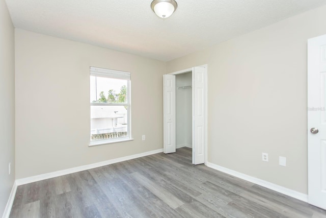 10386 Norvell Rd, Spring Hill, FL 34608 - unfurnished bedroom with wood finished floors, a closet, and a textured ceiling