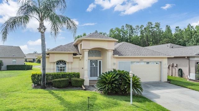 12027 Yellow Finch Ln, Trinity, FL 34655 - view of front of home with stucco siding, a front lawn, driveway, a garage, and a shingled roof