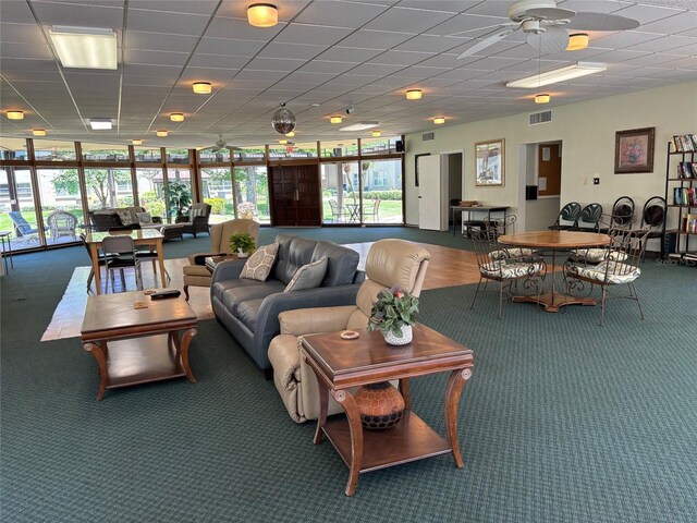 1243 S Martin Luther King Jr Ave Unit C505, Clearwater, FL 33756 - living room featuring plenty of natural light, a ceiling fan, carpet floors, floor to ceiling windows, and a drop ceiling