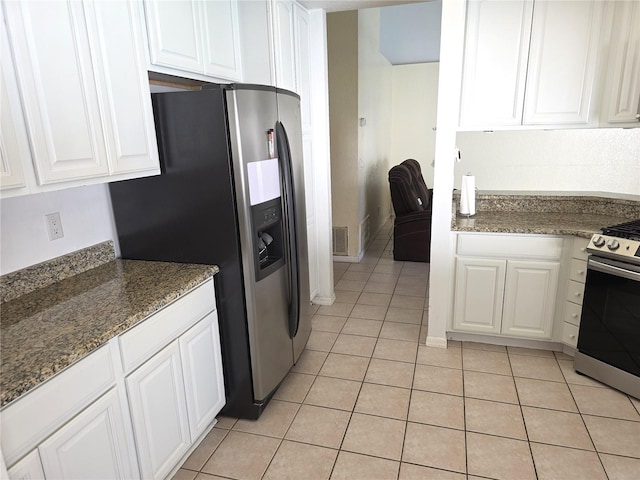 10244 Hoover St, Spring Hill, FL 34608 - kitchen with stainless steel appliances, light tile patterned floors, white cabinets, and dark stone countertops