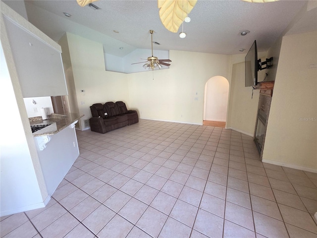 10244 Hoover St, Spring Hill, FL 34608 - kitchen featuring arched walkways, lofted ceiling, ceiling fan, a glass covered fireplace, and light tile patterned flooring