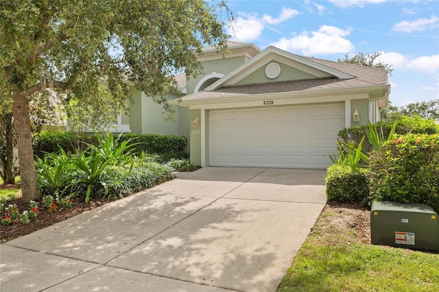 1010 Teal Pointe, Tarpon Springs, FL 34689 - view of front of house featuring stucco siding, concrete driveway, an attached garage, and roof with shingles