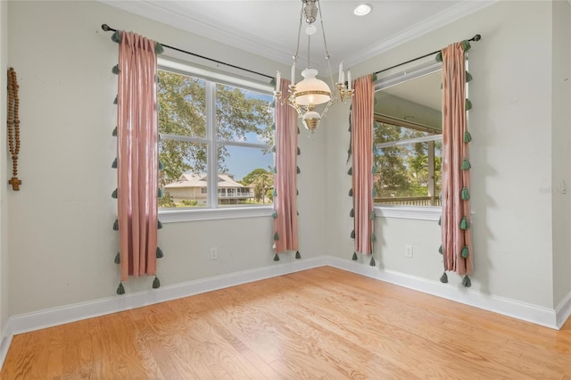 1010 Teal Pointe, Tarpon Springs, FL 34689 - spare room featuring wood finished floors, ornamental molding, plenty of natural light, and a chandelier