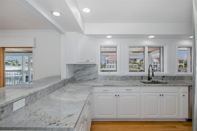 3150 Trident Ter, New Port Richey, FL 34652 - kitchen featuring light stone countertops, white cabinets, a textured ceiling, light wood-style flooring, and recessed lighting