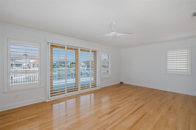 3150 Trident Ter, New Port Richey, FL 34652 - unfurnished room featuring crown molding, light wood-style flooring, healthy amount of natural light, and a ceiling fan