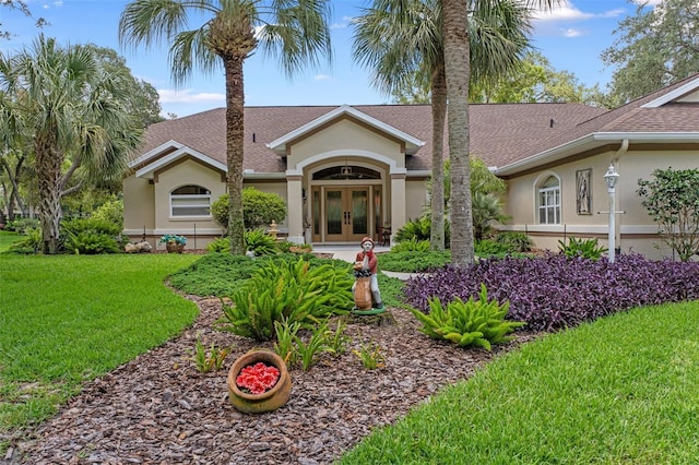 690 E Jenkins Ct, Hernando, FL 34442 - ranch-style home featuring french doors, stucco siding, a front lawn, and roof with shingles