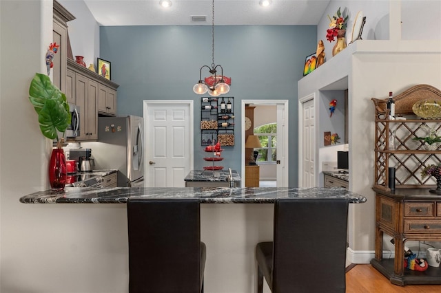690 E Jenkins Ct, Hernando, FL 34442 - kitchen featuring stainless steel appliances, decorative light fixtures, a high ceiling, dark stone countertops, and a chandelier