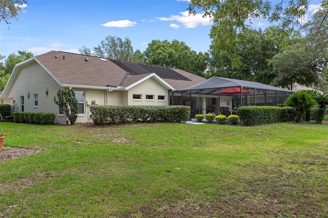 690 E Jenkins Ct, Hernando, FL 34442 - back of property with stucco siding, a lawn, a shingled roof, and a lanai